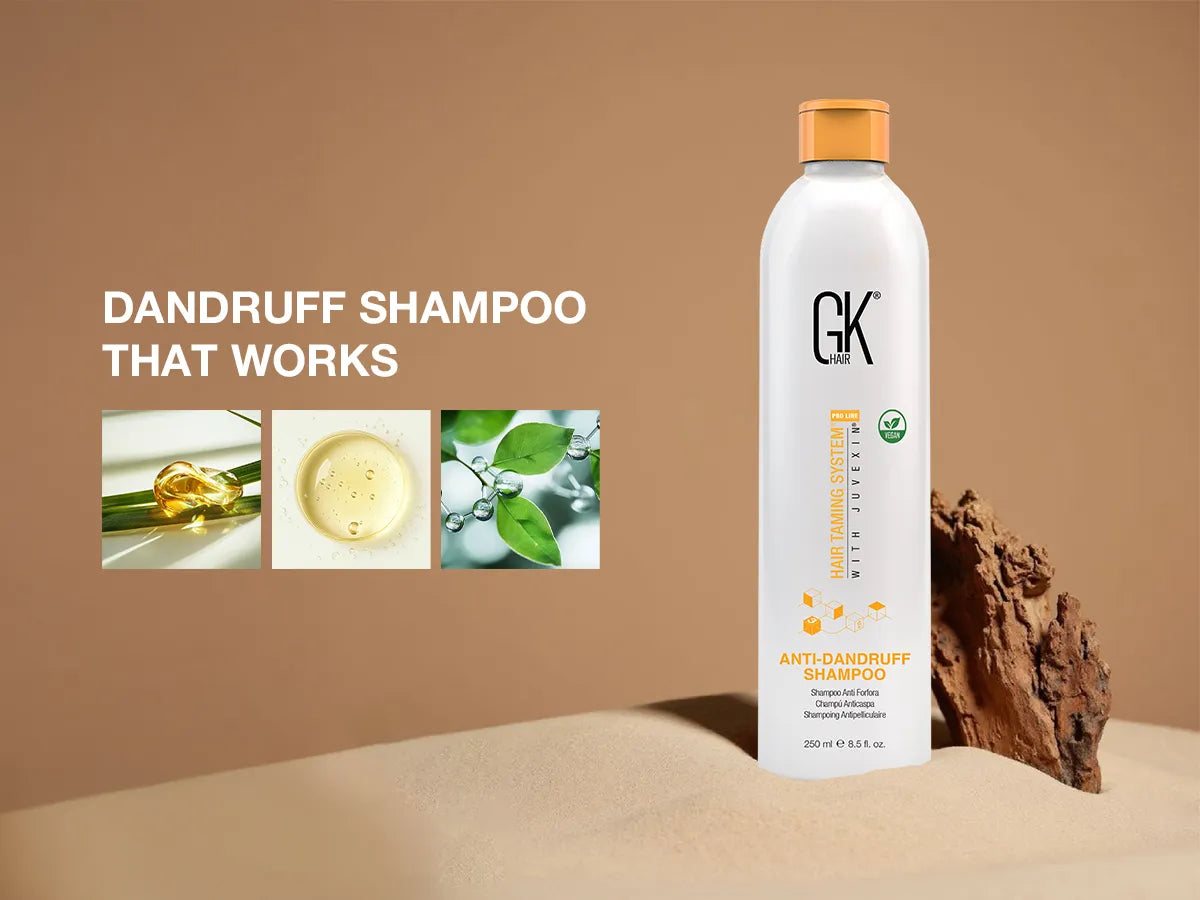 A bottle of GK Hair Anti-Dandruff Shampoo on a sandy backdrop, with images of natural ingredients like oil and leaves.
