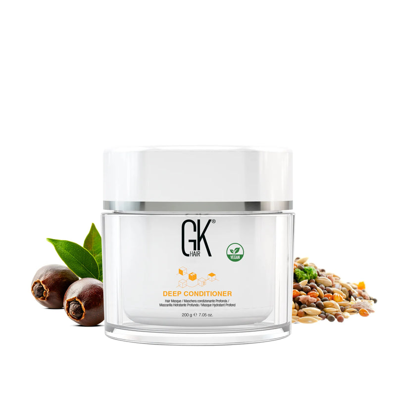 GK Hair Deep Conditioner hair masque jar, 200 g 7.05 oz, marked vegan, between brown seed pods with leaves and mixed grains