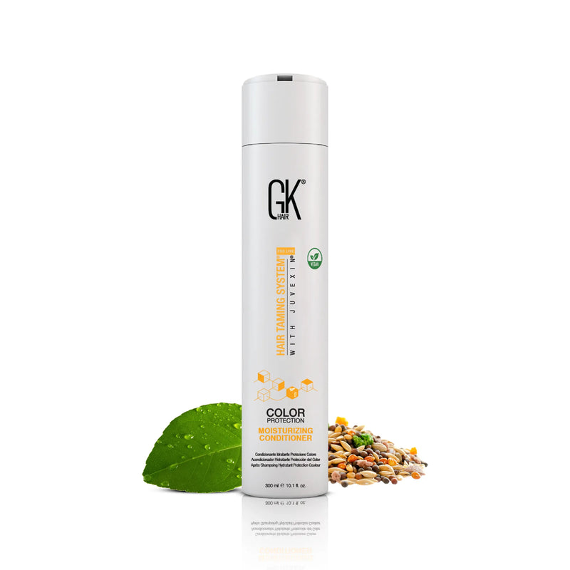 GK Hair Moisturizing Conditioner 300 ml white bottle with a white cap, front view, next to a dewy green leaf and a pile of grains